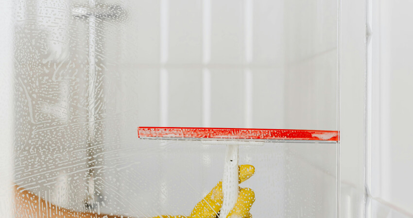 Using squeegee to clean shower glass